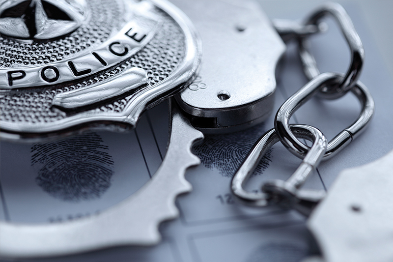 Close up of an officer's badge and handcuffs.
