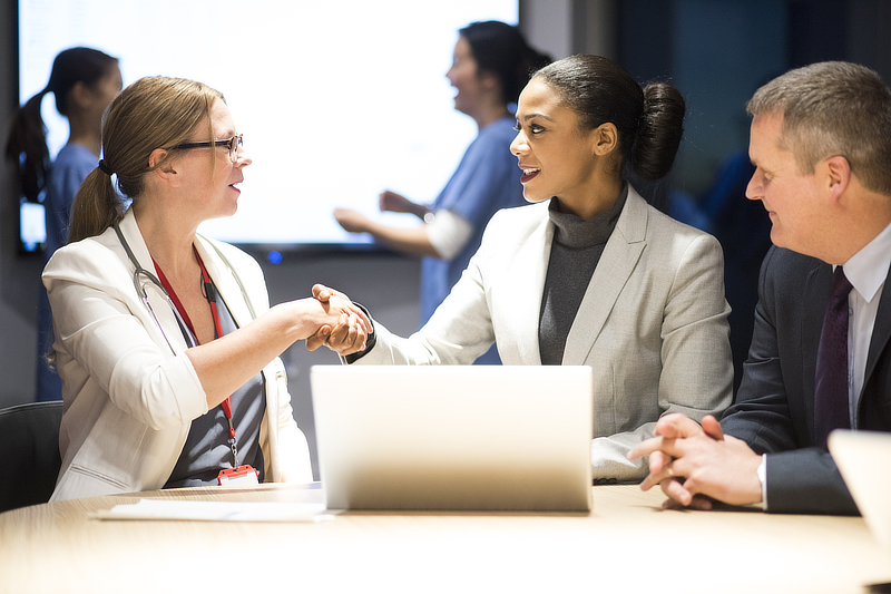 Two business women shaking hands after making an agreement.