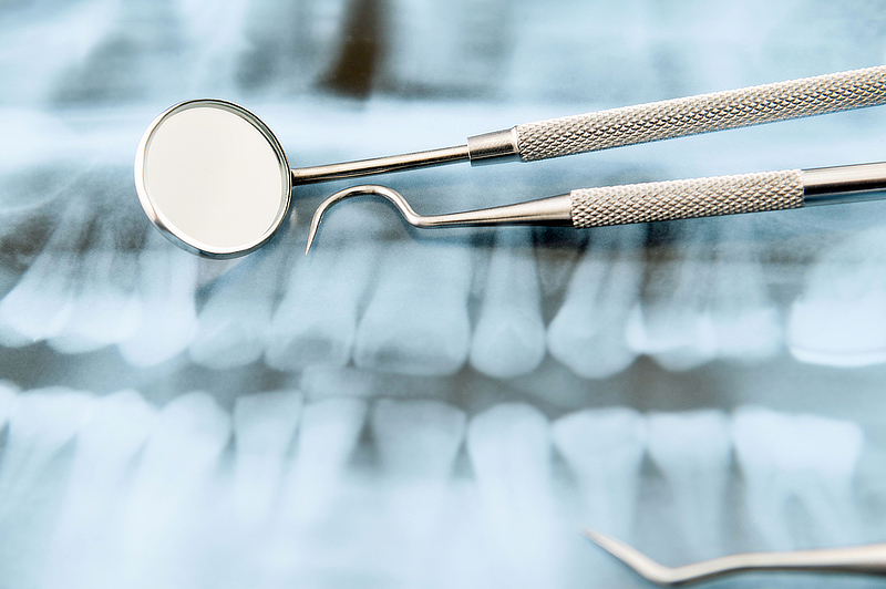 Dentist equipment sitting on top of an x-ray image.